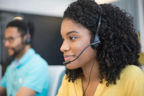Customer service agent wearing a headset using a CX system to manage support calls