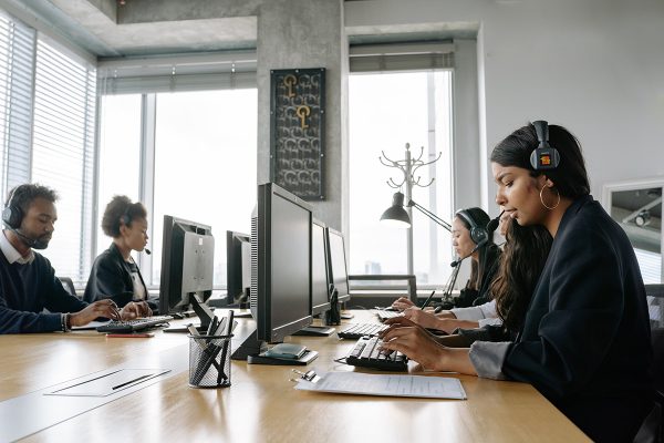 Call center agents supporting customer support quality assurance in front of desktops